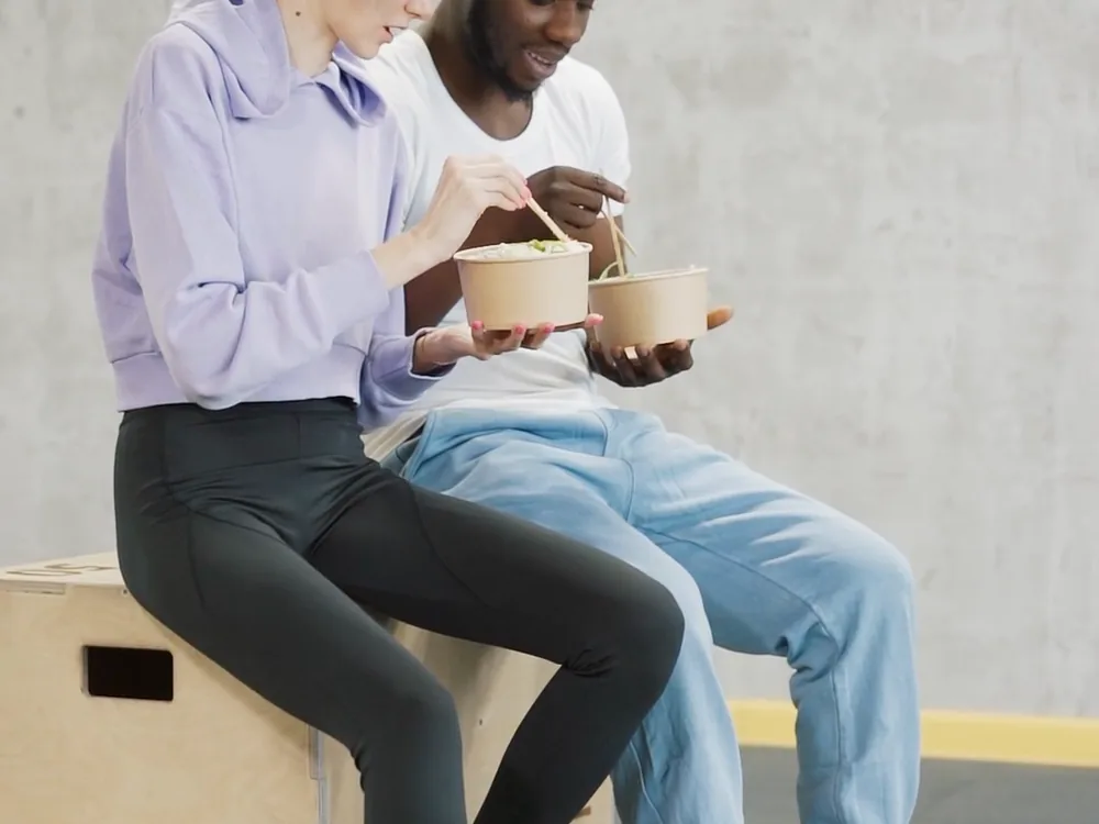 Two colleagues reviewing work on a phone