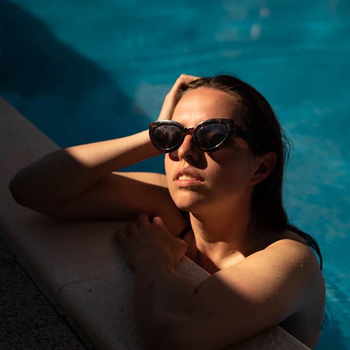 Sunglasses concept by a pool