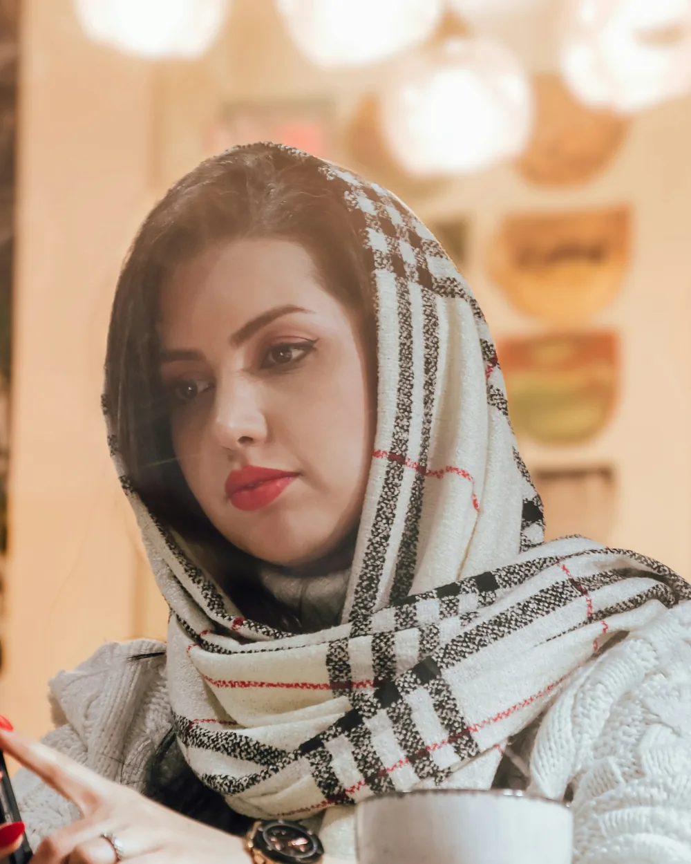 A woman in a scarf looking down at her phone
