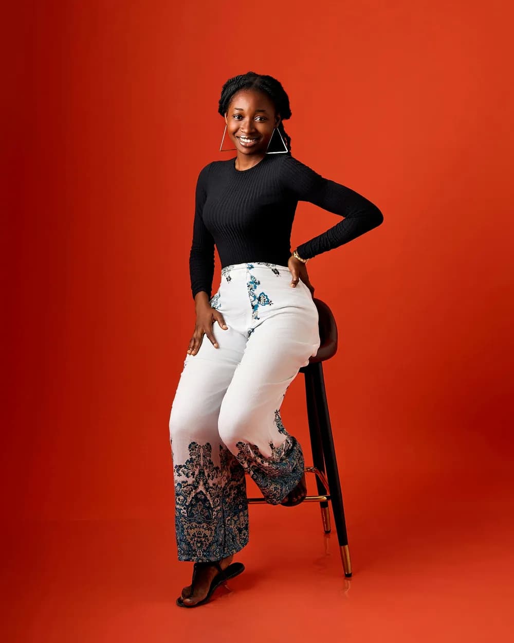 The same woman seated on the stool