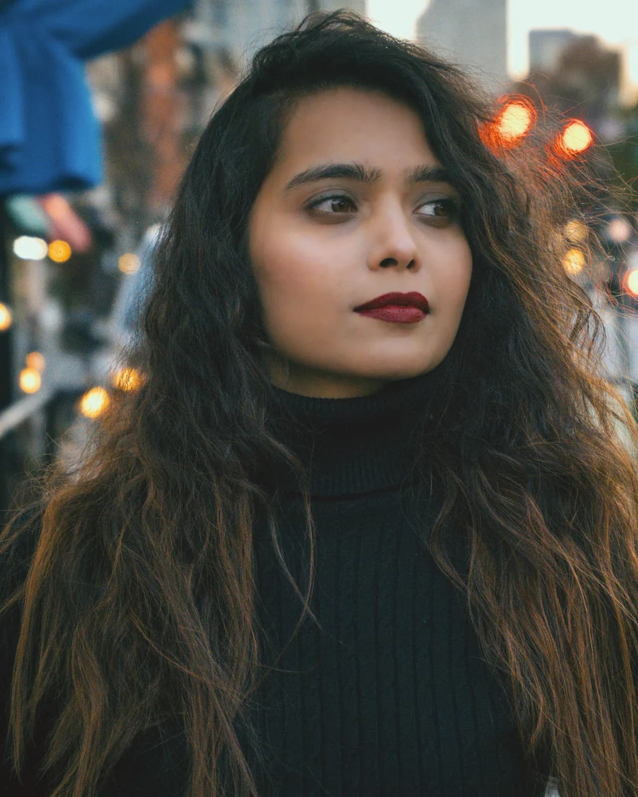 A woman with long hair on a city street at night