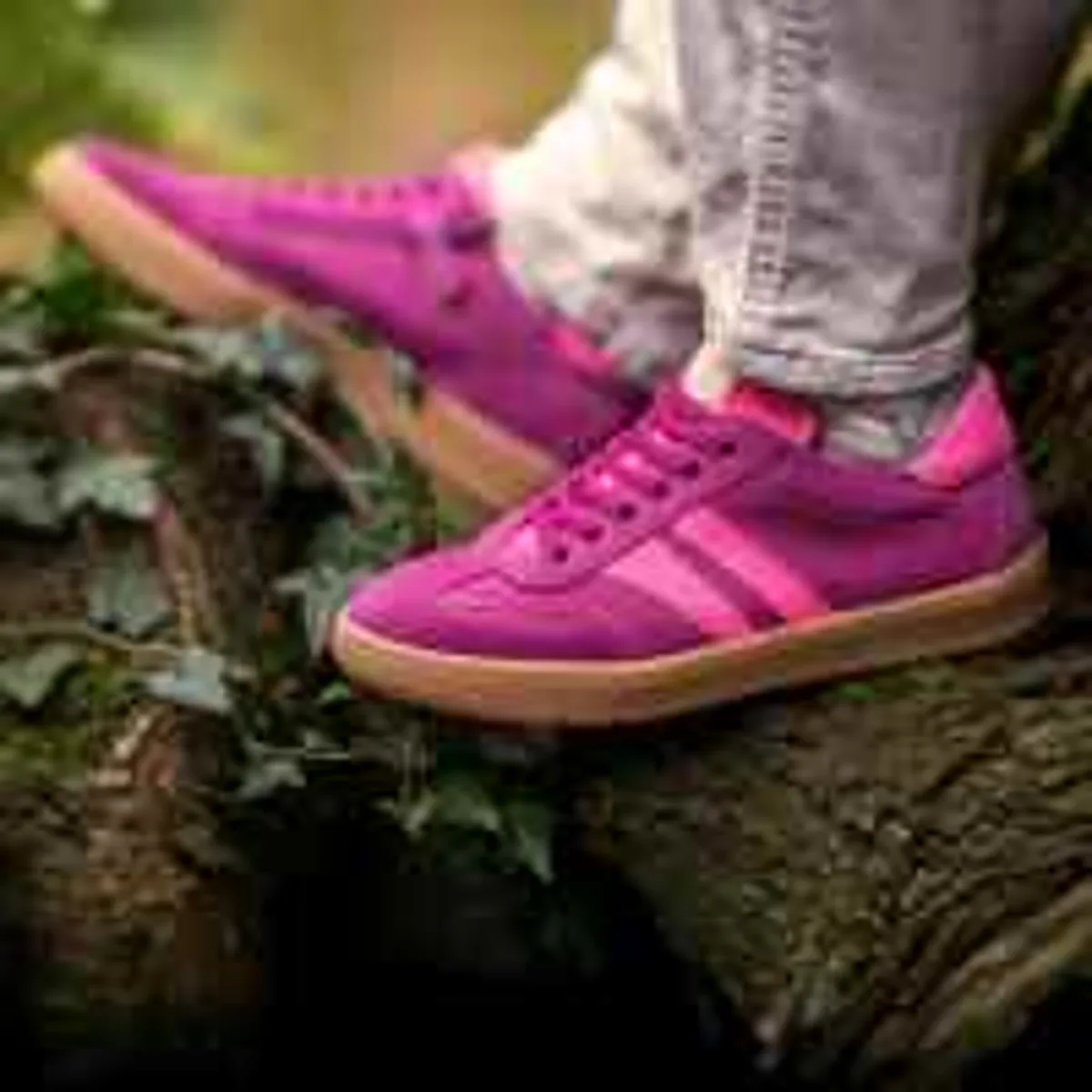 Low-resolution pink sneakers on a mossy log
