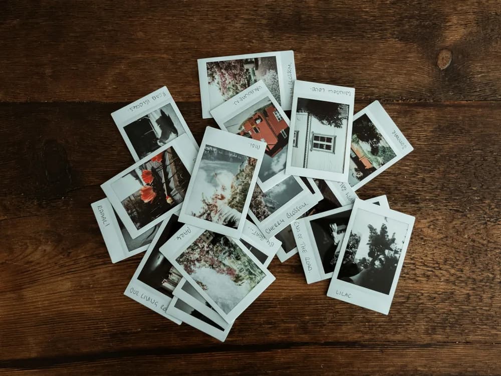 Instant photo prints scattered on a wooden table
