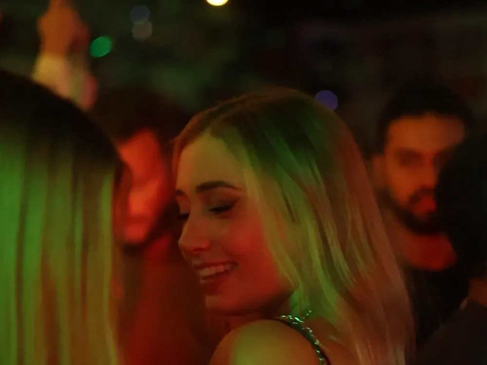People dancing under coloured club lights