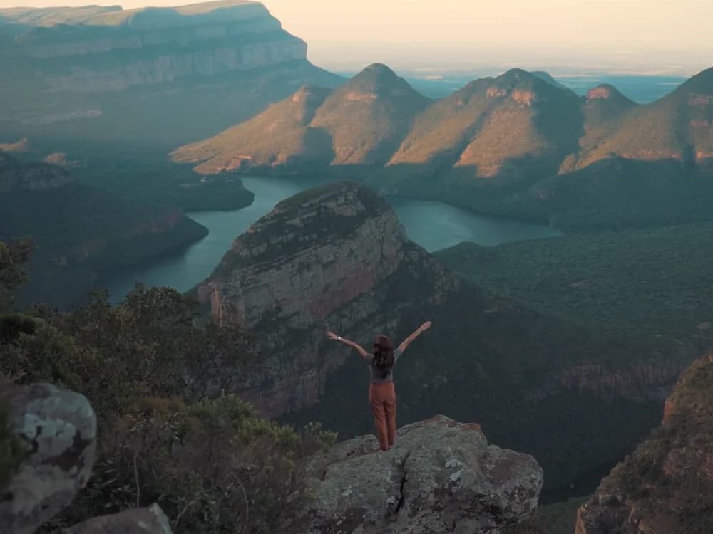 A woman on a rock above a canyon