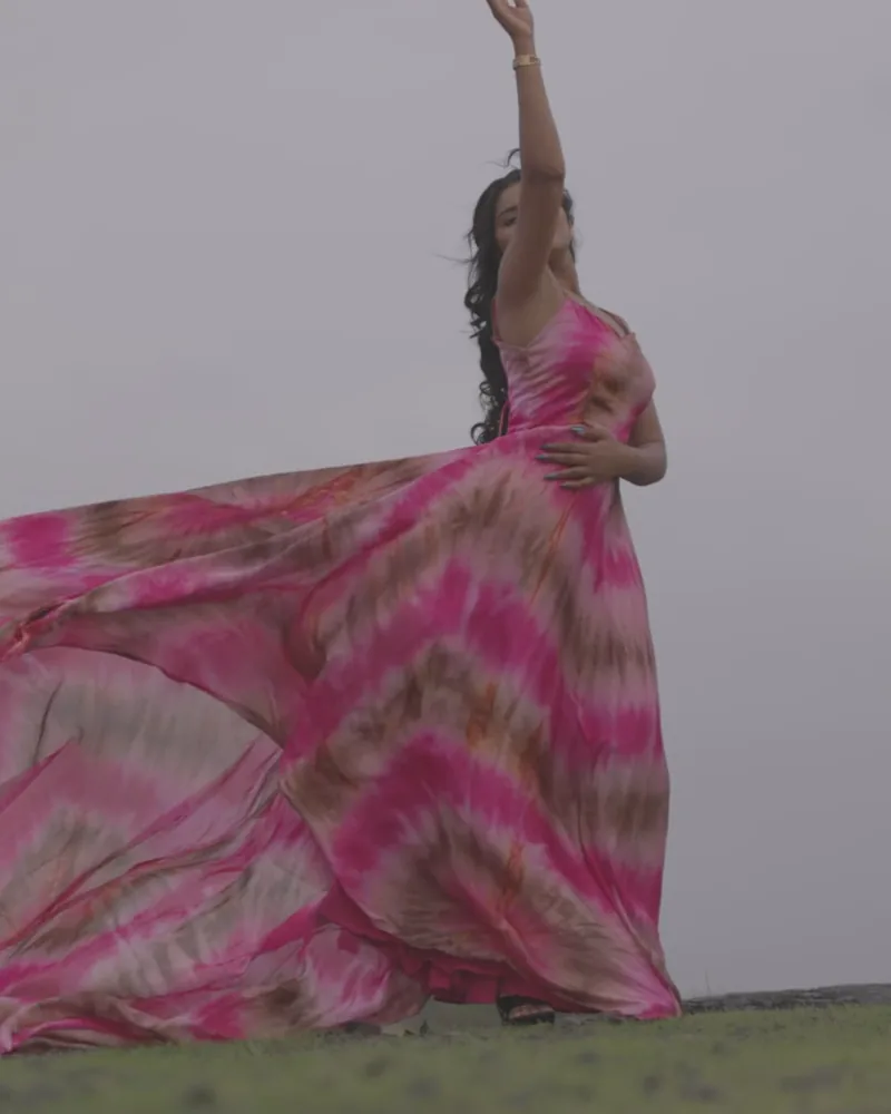 A woman in a pink dress, arm raised