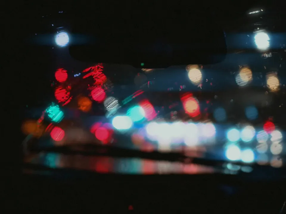 City lights through a rain-streaked windshield
