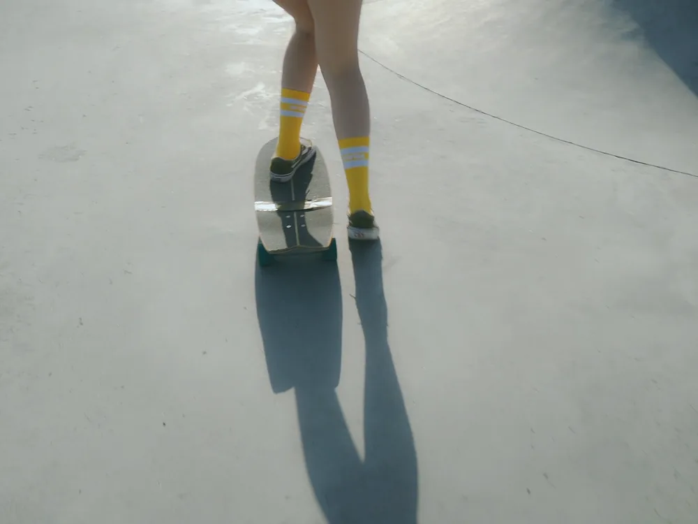 Yellow socks on a skateboard in a concrete bowl