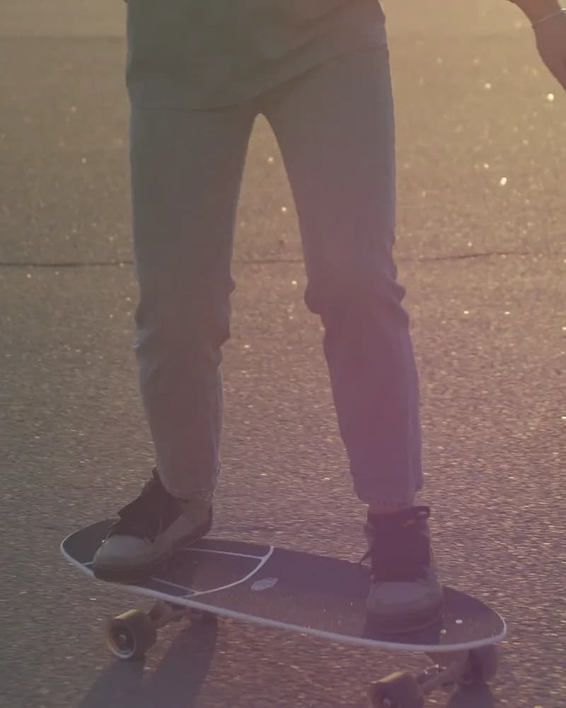 The skater’s shoes on the board in low sun