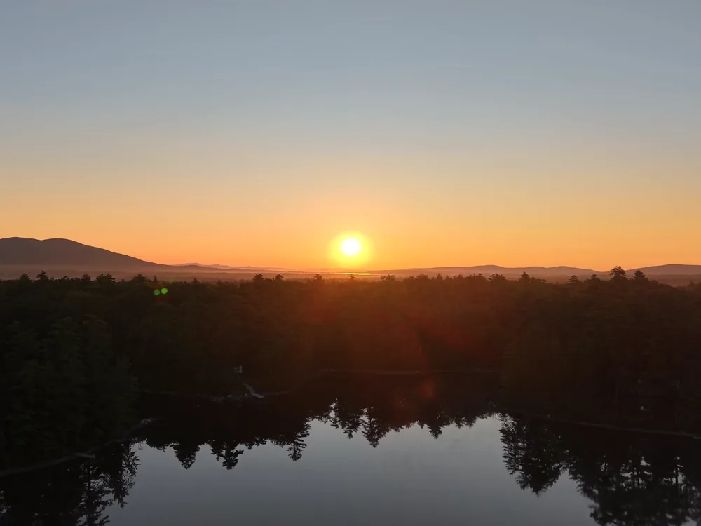 The sun setting over a still lake
