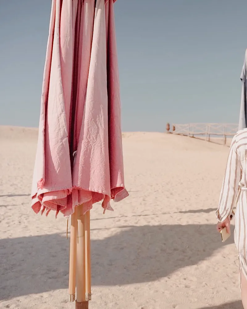 A closed pink beach umbrella