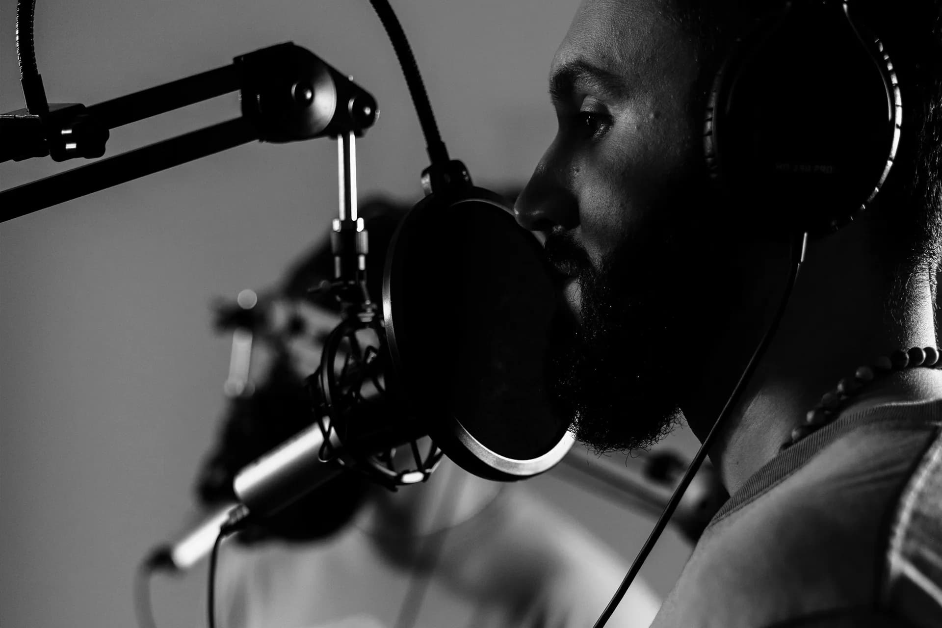 A man with headphones recording at a microphone