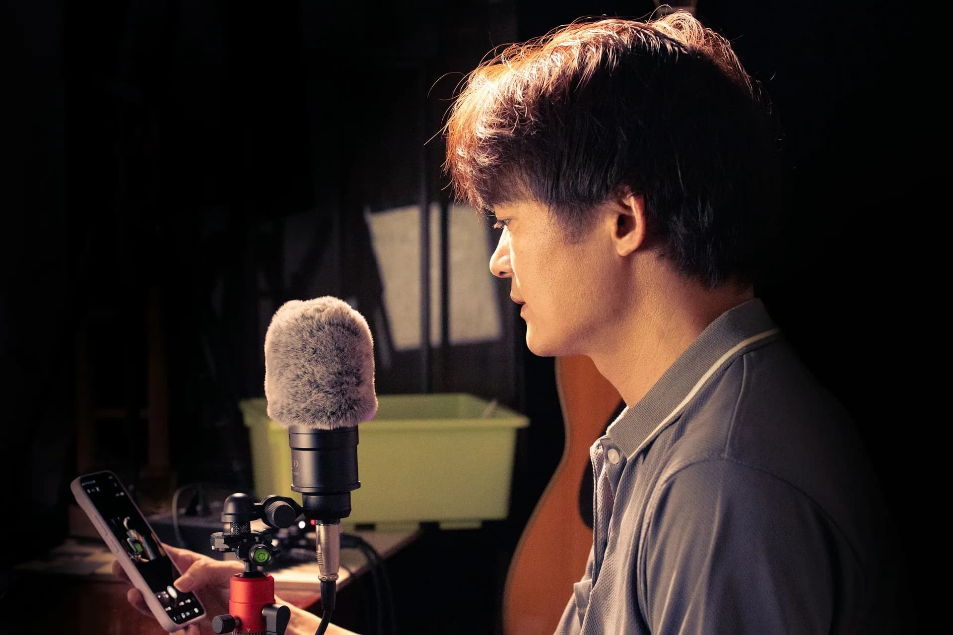 A man speaking into a studio microphone